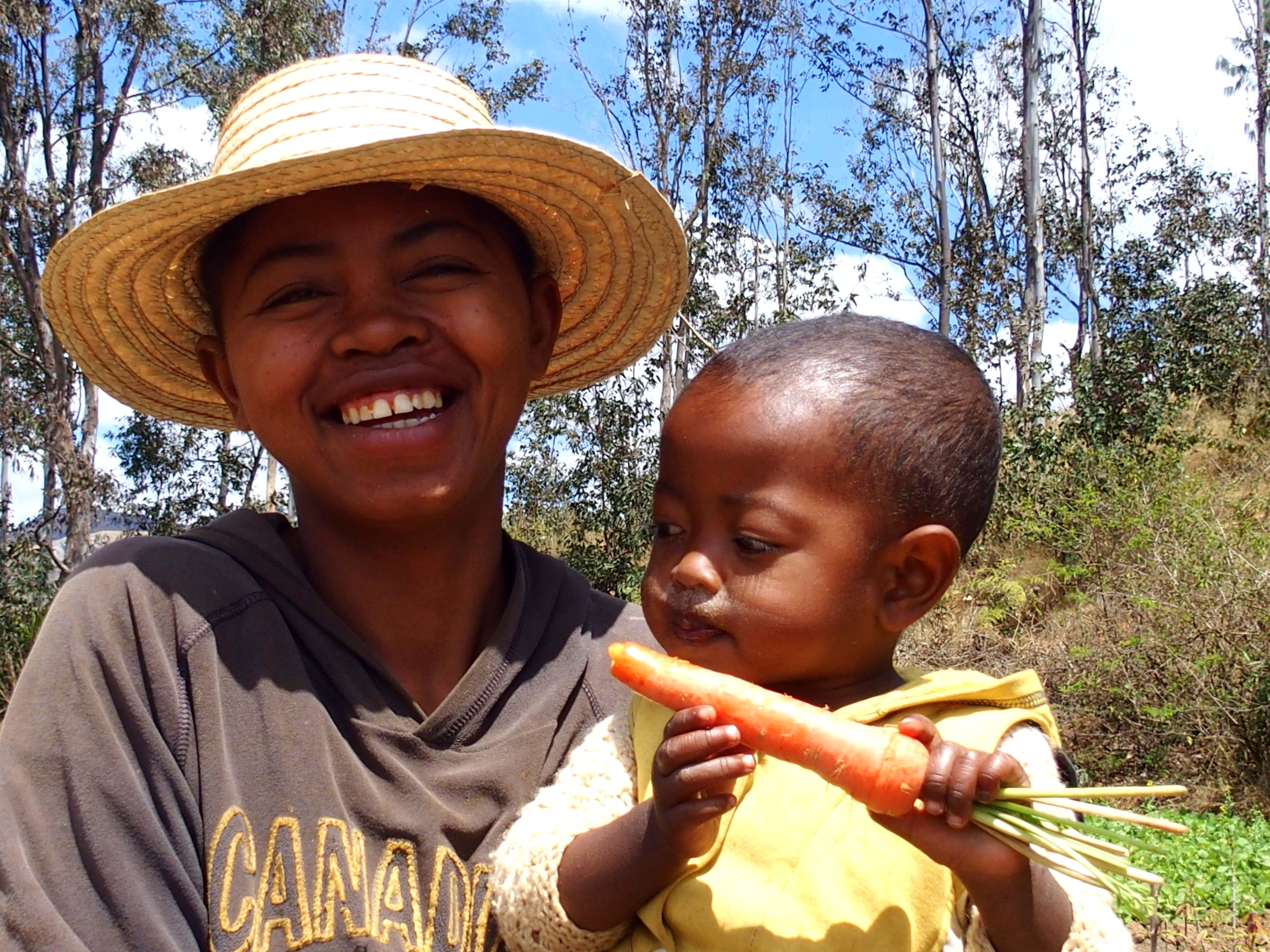 Mère et fils mangeur de carotte dans un champ à Madagascar
