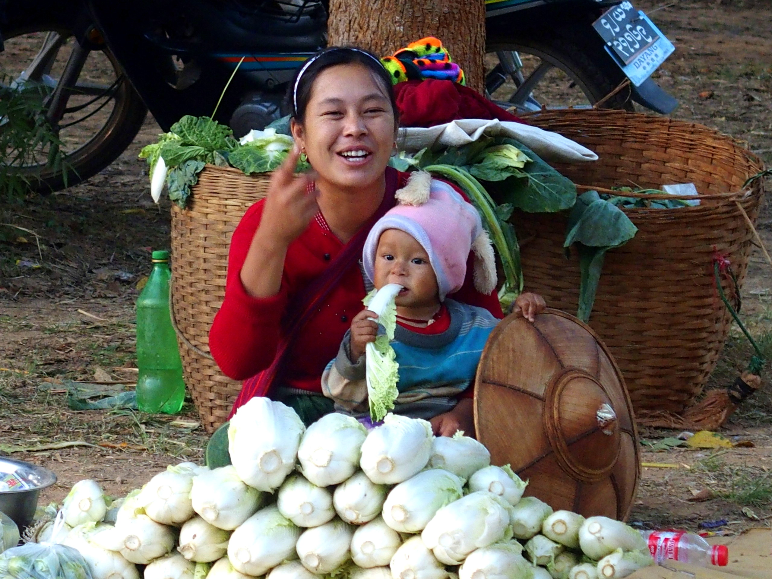 Vendeuse et enfant mangeur de choux marché Bago Myanmar